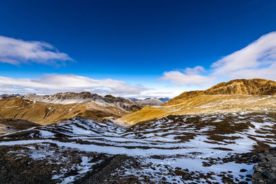 Scenic view of snowcapped mountains against blue sky