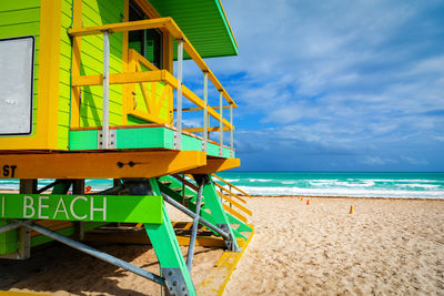 Lifeguard hut on beach against sky