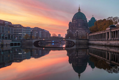 Reflection of buildings in river during sunset
