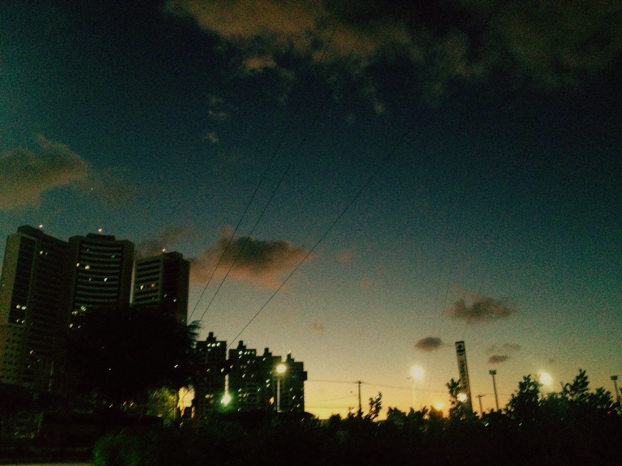 architecture, built structure, illuminated, sky, building exterior, silhouette, dusk, cloud, dark, scenics, tranquil scene, outline, tall, outdoors, tranquility, tall - high, beauty in nature, cloud - sky, urban skyline, no people, city life