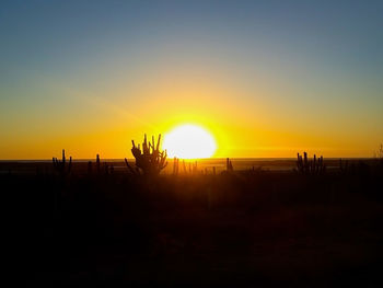 Scenic view of silhouette landscape against orange sky