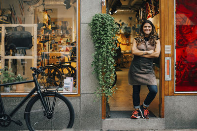 Portrait of woman standing by bicycle