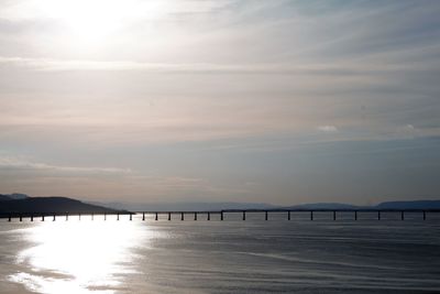 Pier over sea against sky during sunset