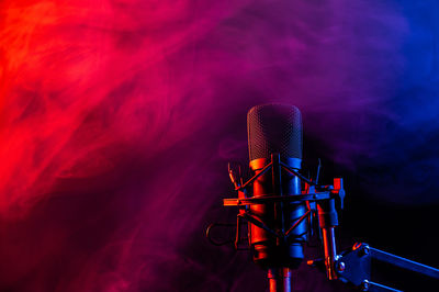 Professional microphone in pink smoke on a black background.