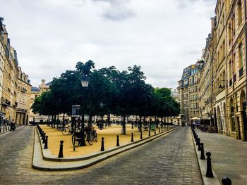 Street amidst buildings against sky in city