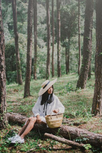 Woman sitting on log in forest