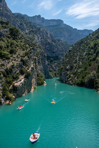 High angle view of boats on sea by mountain