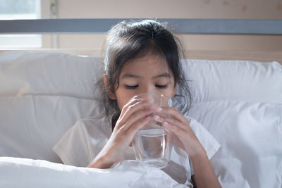 Girl drinking water while relaxing at home