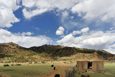 Panoramic view of old ruins on field against sky