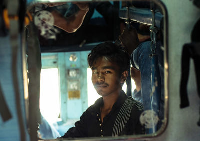 Portrait of young man sitting in car