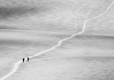 People climbing on snow covered mountain at swiss alps