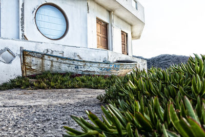 Wheathered fishing boat in front of an abandoned house in the village of mochlos island of crete