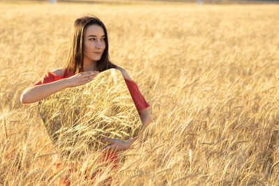 Portrait of young woman standing on hay