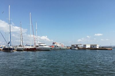 Sailboats moored on sea against sky