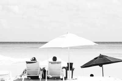 Rear view of couple sitting on beach