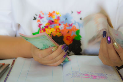 Close-up of woman reading book on table