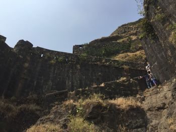 People on wall against clear sky