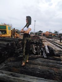 Woman standing on railroad track against sky