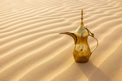 Close-up of jug on sand at beach