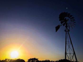 Low angle view of silhouette windmill against sky during sunset