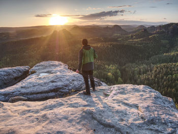 Photographer is setting tripod and camera for an art work. hiker  takes photos with camera on tripod