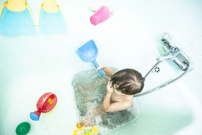 Full length of baby boy playing in water at home