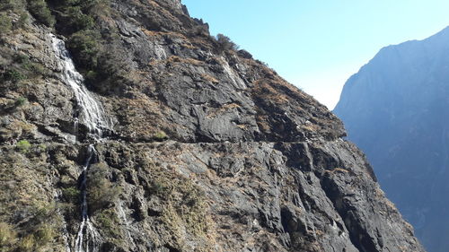 Low angle view of rocky mountains against sky