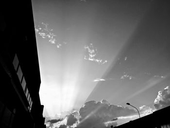 Low angle view of silhouette buildings against sky on sunny day