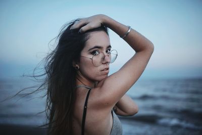 Portrait of woman on beach against sky