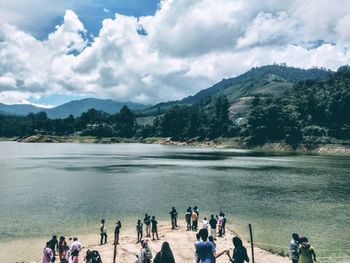 People at beach against sky