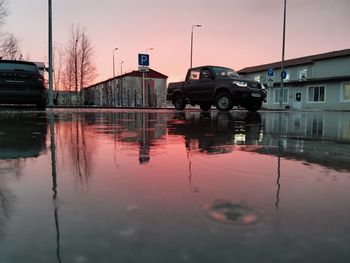 Reflection of building in puddle during sunset