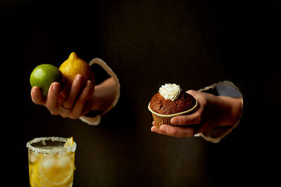 Close-up of hand holding fruit on table