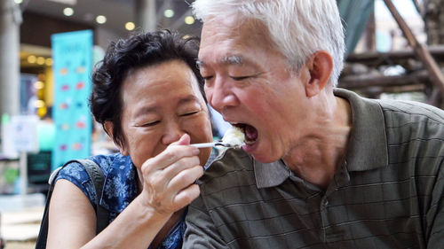 Cute smiling old couple eating ice cream 