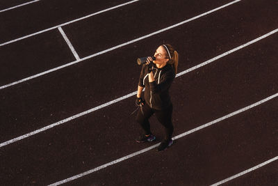 High angle view of young woman running on road