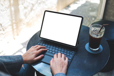 Midsection of woman using laptop on table