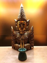 Close-up of buddha statue on table