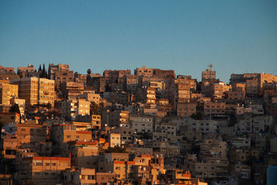 Buildings in city against clear blue sky