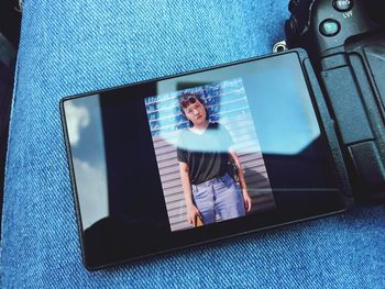 Midsection of woman with photograph on camera screen