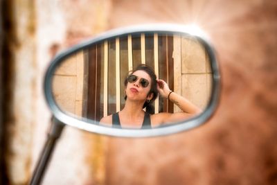 Portrait of woman photographing reflection on mirror