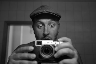 Portrait of shocked mature man photographing with camera