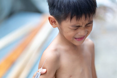 Cropped hand of doctor injecting boy