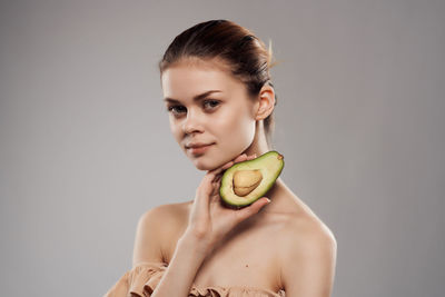 Portrait of smiling young woman against white background