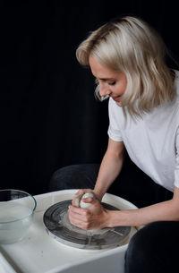 Ceramist works behind a potter's wheel