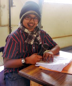 Portrait of smiling young woman sitting on table