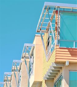 Low angle view of staircase by building against clear blue sky