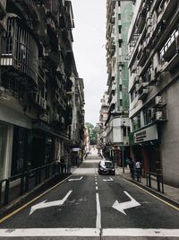 Cars on road in city against sky