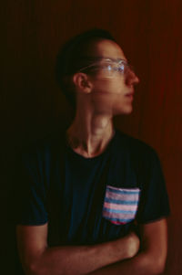 Portrait of young man looking away over black background