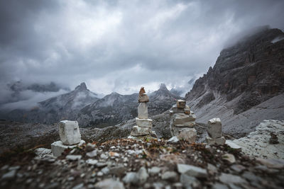 Stone wall by mountains against sky