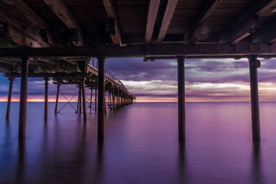 Pier on sea against sky during sunset