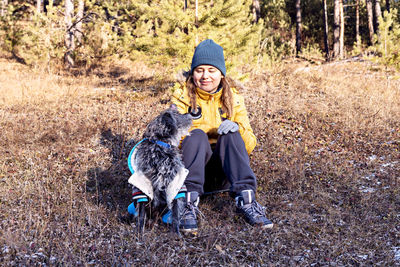  smiling woman in yellow jacket playing with mixed breed dog in warm suit forest autumn  pet adoption 